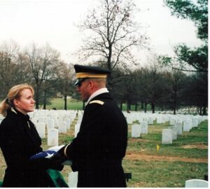 Genealogist Megan Smolenyak receives the flag of a soldier at Arlington National Cemetery.